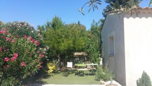 a garden with a table and chairs next to a building at Au Bon Penequet in Pujaut +7 photos