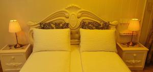 a bedroom with a yellow bed with two lamps at Cosy House Kaunas & Parking in Kaunas