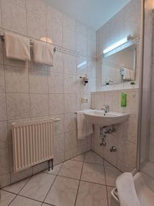 een witte badkamer met een wastafel en een douche bij HoFer am Zeitberg Ferienwohnung Echelsbach in Bad Kohlgrub