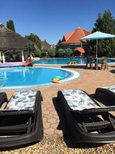 2 matelas vides assis à côté d'une piscine dans l'établissement Kata Apartman Siófok, à Siófok