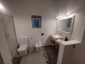 y baño con 2 aseos, lavamanos y espejo. en Casa Ines en Guatiza