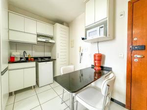 eine Küche mit einem Tisch und Stühlen im Zimmer in der Unterkunft Park Studios Vaga Garagem in Brasilia