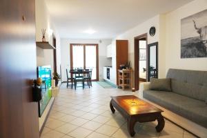 ein Wohnzimmer mit einem Sofa und einem Tisch in der Unterkunft Bell Tower Apartament in Aviano in Aviano