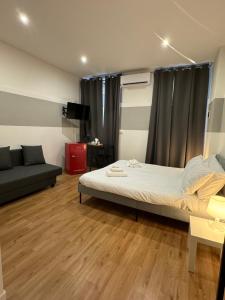 a small bedroom with a bed and a couch at Il Tasso Rooms & Apartments in Trieste