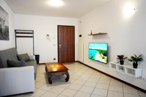 a living room with a couch and a tv on a wall at Bell Tower Apartament in Aviano in Aviano