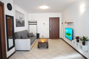 a living room with a couch and a tv at Bell Tower Apartament in Aviano in Aviano