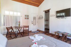Habitación con cama, mesa y TV. en Pousada Vila do Campo, en Lavras Novas