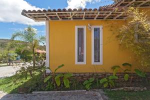 een geel huis met een raam aan de zijkant bij Pousada Vila do Campo in Lavras Novas