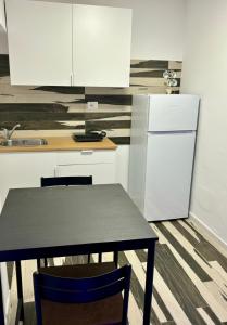 a kitchen with a black table and a refrigerator at Do Mar in Bisceglie +10 photos