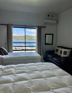 a bedroom with two beds and a large window at Hostal Umantun in Dalcahue