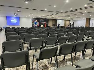 uma sala cheia de cadeiras e um ecrã com uma apresentação em Hotel Dorado Plaza Bocagrande em Cartagena de Indias