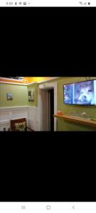 sala de estar con TV de pantalla plana en la pared en Private hideaway at The Phoenix guest suite, en Moss Town