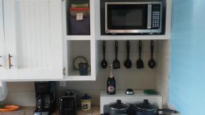 a kitchen with a microwave and utensils on the wall at Private hideaway at The Phoenix guest suite in Moss Town