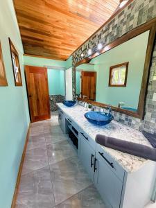 a bathroom with two sinks and two mirrors at Mangata Villas Adults Only in San Pedro