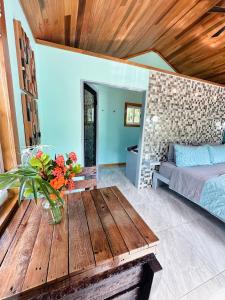 a living room with a wooden table and a bed at Mangata Villas Adults Only in San Pedro