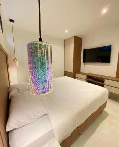 um quarto com uma grande cama branca e um lustre em NOVAPARK HOTEL em Guayaquil