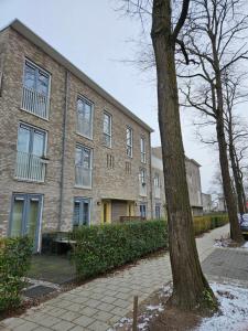 a brick building with a tree in front of it at Residence Dordrecht in Dordrecht