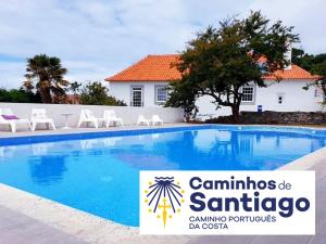 a swimming pool with chairs and a sign in front of it at Solar Laginha - apartamentos, quartos, camas em dormitório in Afife