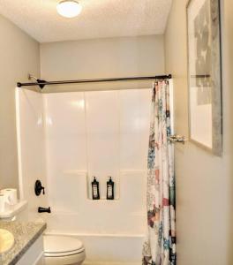 a bathroom with a shower curtain and a toilet at Lake Livingston Family Fun Getaway Serene Sunsets! in Livingston