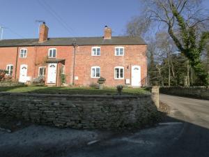 a large red brick house with a stone wall at 1 Tump Cottages in Hereford