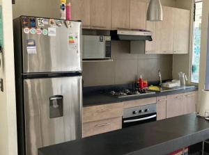 a kitchen with a stainless steel refrigerator and cabinets at Departamento amoblado en Constitución in Constitución