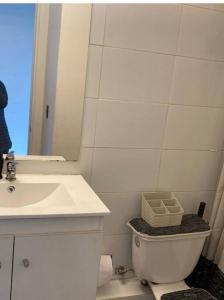 ein Badezimmer mit einem Waschbecken, einem WC und einem Spiegel in der Unterkunft Departamento amoblado en Constitución in Constitución