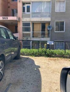 une voiture garée dans un parking en face d'un bâtiment dans l'établissement Departamento amoblado en Constitución, à Constitución