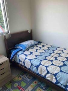 a bedroom with a bed with a blue and white comforter at Departamento amoblado en Constitución in Constitución