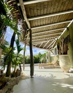 um pátio com palmeiras e um telhado de madeira em Villa Tilanga em Saint-François