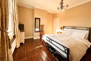 a bedroom with a large bed and a window at Two Bedroom Period Property in Tivoli Cheltenham in Cheltenham