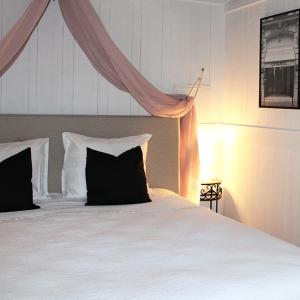un letto con cuscini bianchi e neri in una camera da letto di Les Rocailles a Lamonzie-Montastruc