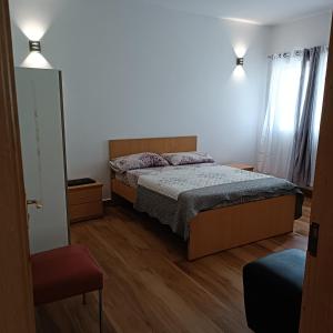 Schlafzimmer mit einem Bett und einem Fenster in der Unterkunft Espaço-Vila Verde 