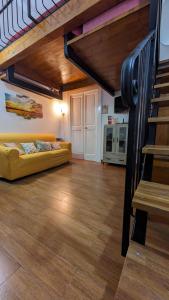 a living room with a yellow couch and a loft at Honeyapartment in Brindisi