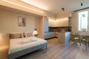 Un dormitorio con una cama y una mesa y una cocina. en Palazzo Marsili Serenity, en Bolonia