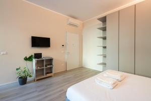 ein Schlafzimmer mit einem Bett und einem TV an der Wand in der Unterkunft Palazzo Marsili Serenity in Bologna
