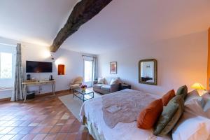 a bedroom with a bed and a living room at Hotel Le Mas Trilles in Céret