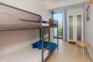 a room with two bunk beds and a table at Sa Perdiu 14 in Cala Santandria