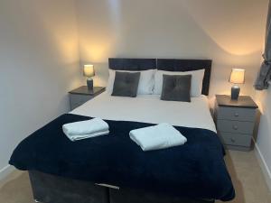 um quarto com uma cama grande e 2 almofadas em Kingsway House - Brand New Spacious 4 Bed Home From Home em Derby
