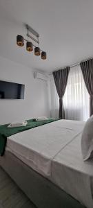 a bedroom with a large white bed with a window at Relax Home Apartment Q in Iaşi