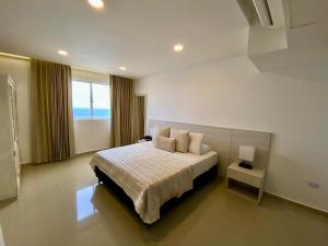 a bedroom with a large bed and a window at Hotel Dorado Plaza Bocagrande in Cartagena de Indias