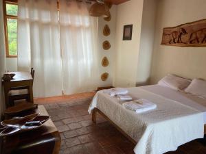 a bedroom with a bed and a table and a window at Casa Hospedaje Sangapilla in Lamas