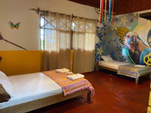 a bedroom with two beds and a painting on the wall at Casa Hospedaje Sangapilla in Lamas