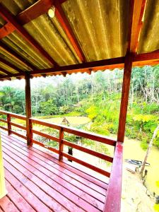 een houten veranda met uitzicht op een rivier bij Sítio Nature in Rancho Queimado