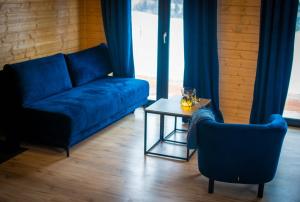 a living room with a blue couch and a table at Widokowe Stodoły balia z hydromasażem na wylączność in Chyżówki