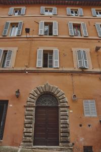 un edificio naranja con una puerta y ventanas marrones en Holiday House CAMILLO BENSO, en Perugia