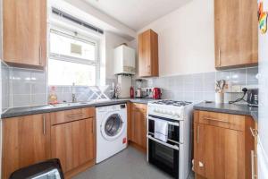 a kitchen with a washing machine and a washer at Central Ground Floor Flat Free Parking in London