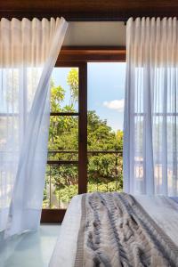 - une chambre avec un lit et une grande fenêtre dans l'établissement Refúgio na Serra Boutique Hotel, à Mucugê
