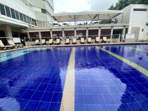 a large swimming pool with chairs and a building at Hotel Dorado Plaza Bocagrande in Cartagena de Indias