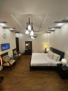sypialnia z łóżkiem, kanapą i telewizorem w obiekcie Harveys Guest House w mieście Islamabad