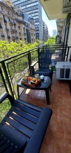 balcón con mesa y sillas en Cómodo departamento con balcón en Microcentro en Buenos Aires
